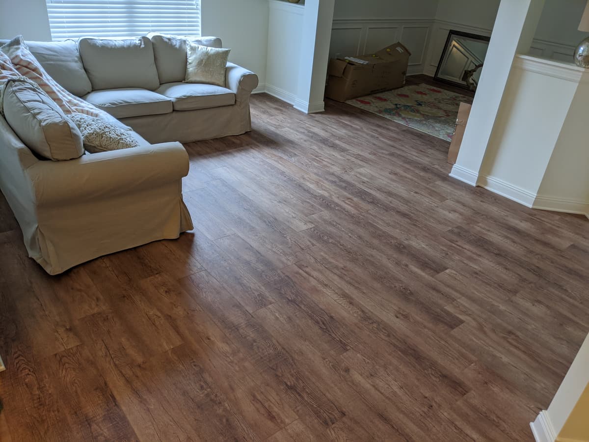 Warm luxury vinyl plank in a living room with a cream sofa