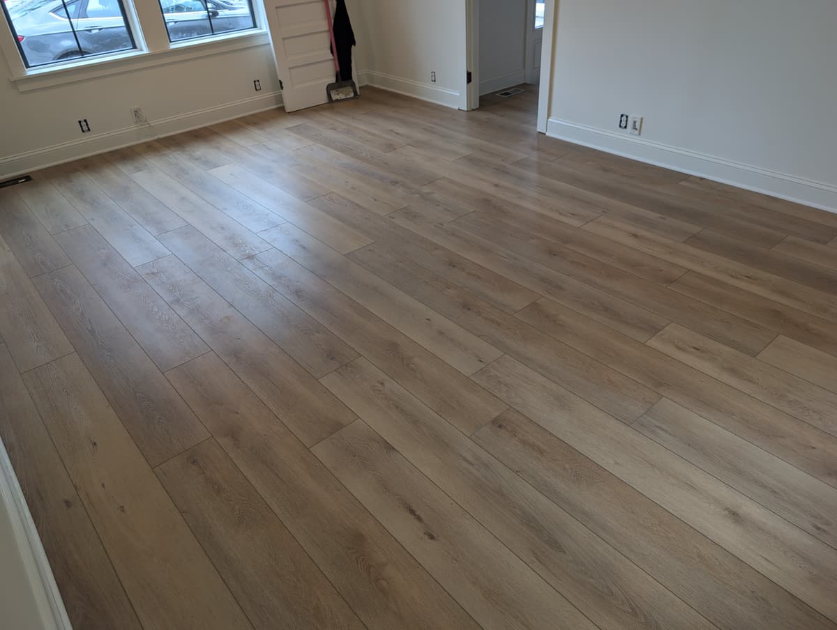 Mid-tone luxury vinyl plank across an empty room