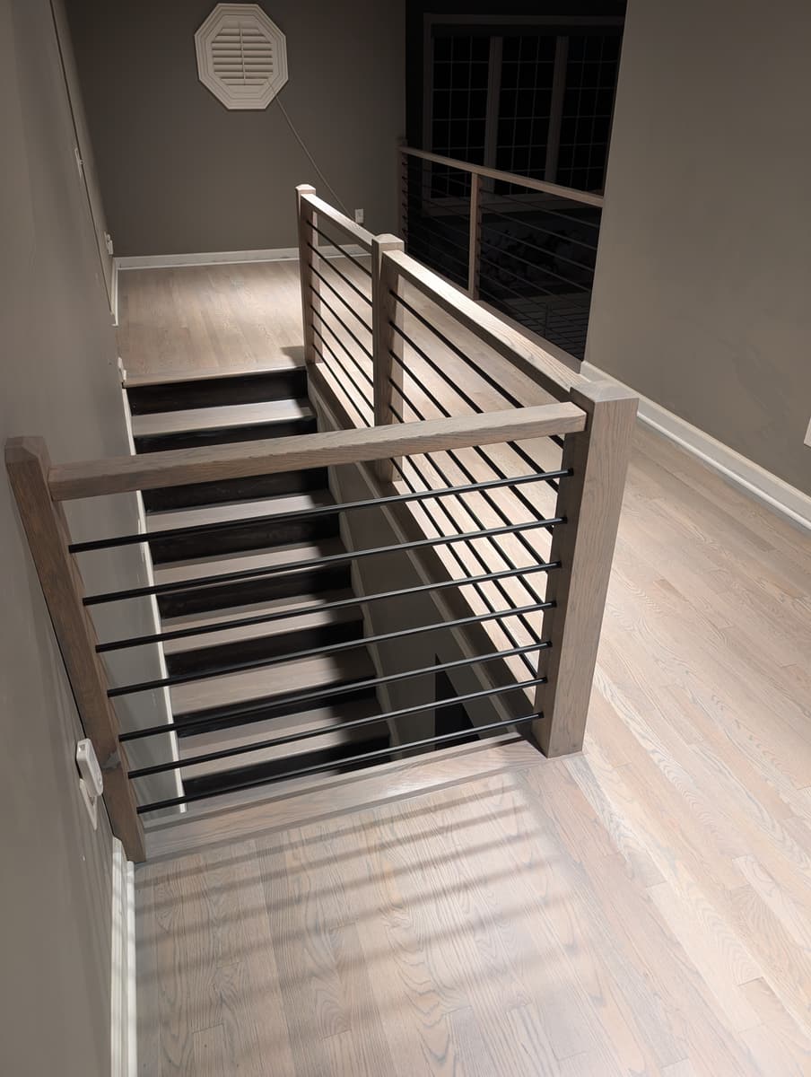 A modern horizontal-bar railing over dark stair treads