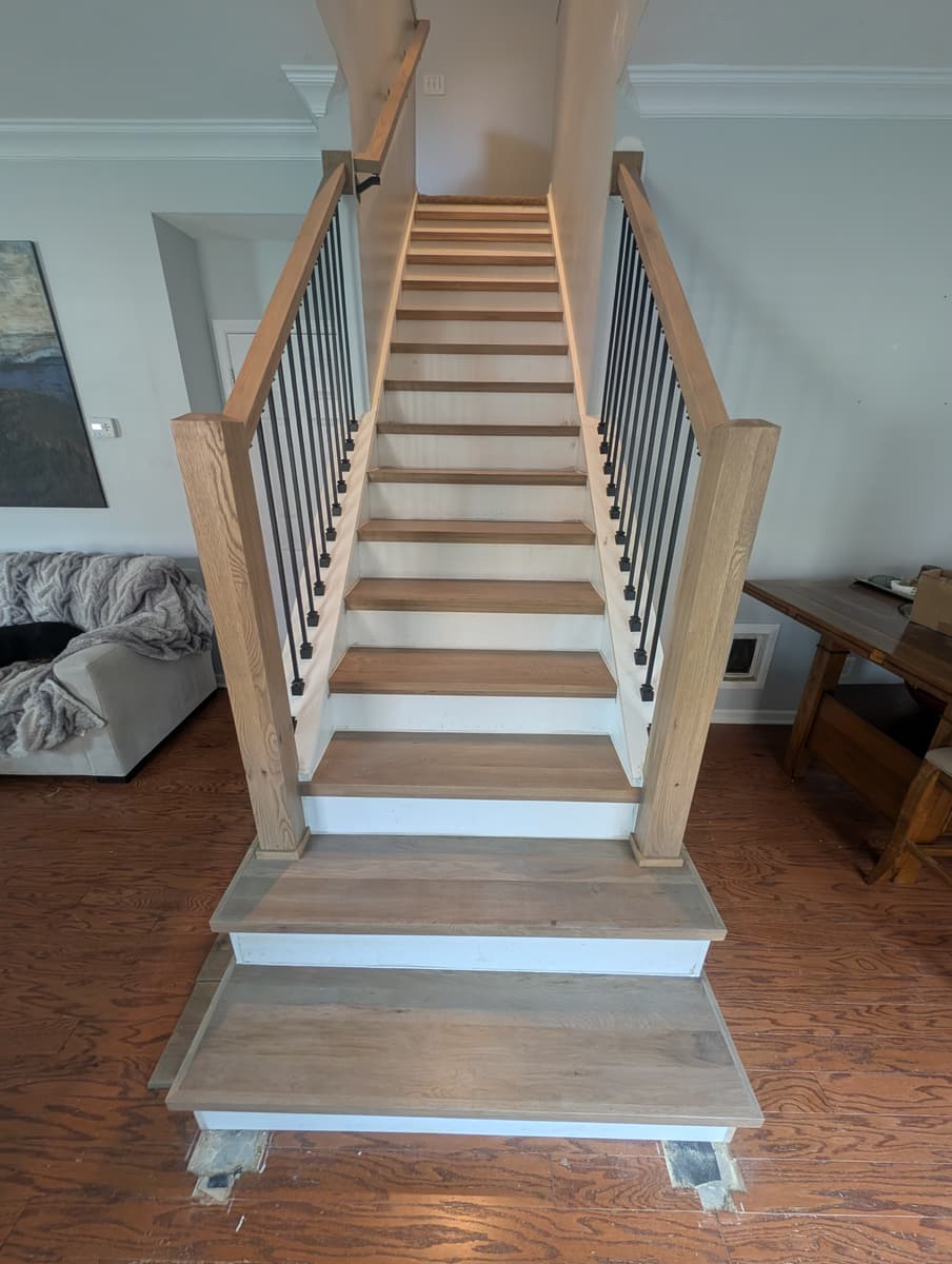 A straight staircase with new oak treads, white risers and oak newel posts