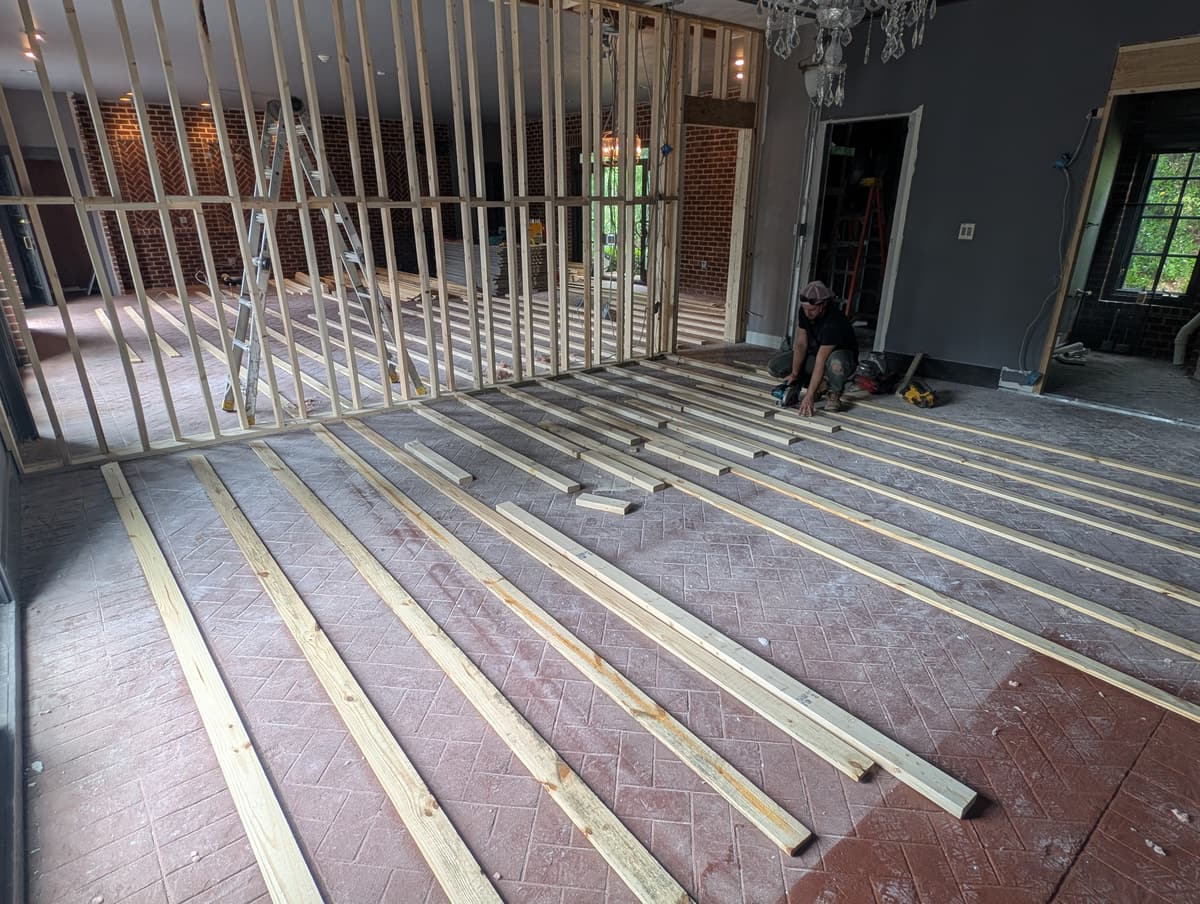 Wood sleepers being laid in rows across a room to carry a new subfloor